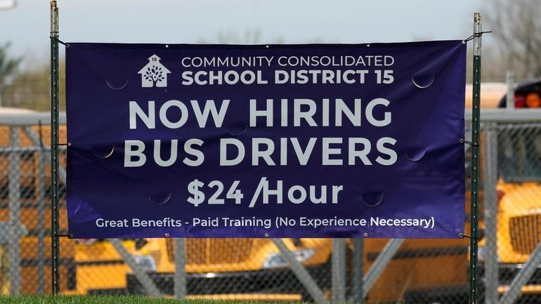 File - A hiring sign seeking bus drivers is posted...