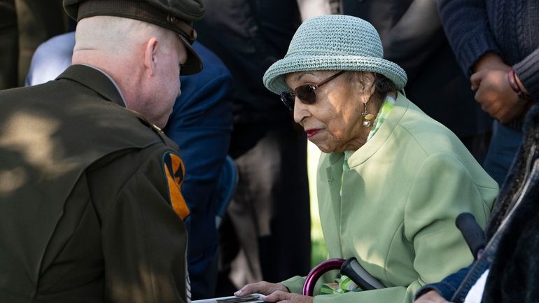 First Army's Command Sgt. Maj. Chris Prosser, left, presents Joann...