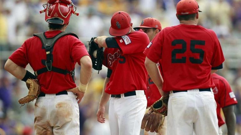 Stony Brook pitcher James Campbell (15) wipes his brow in...