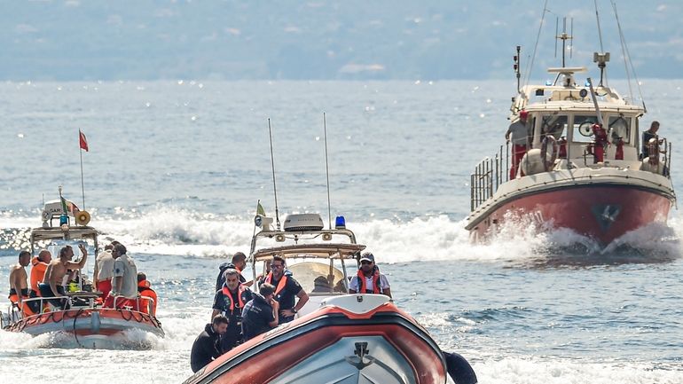 Italian firefighter divers work at the site of a shipwreck,...