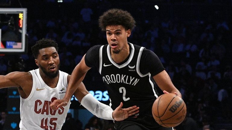 Nets forward Cam Johnson drives the ball past Cleveland Cavaliers...