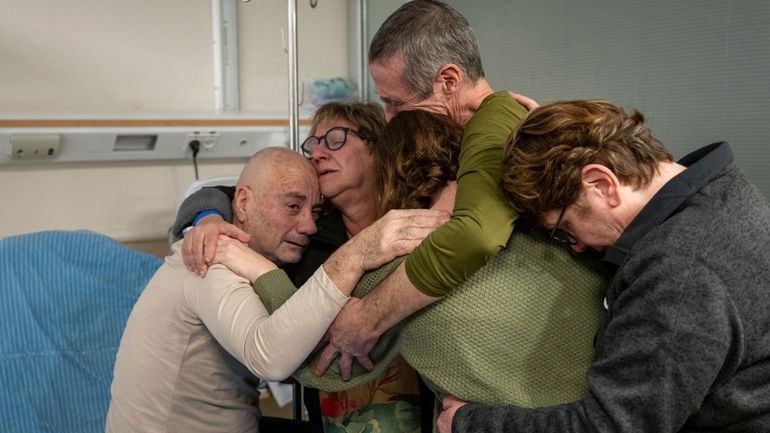 Hostage Luis Har, left, is hugged by relatives after being...