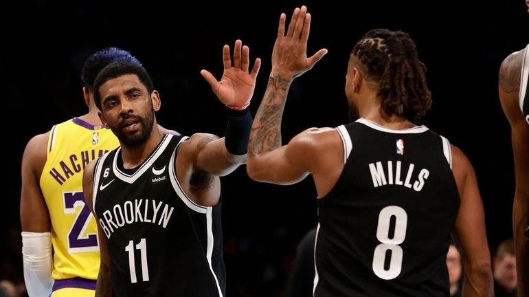 Kyrie Irving and Patty Mills of the Nets react after a...