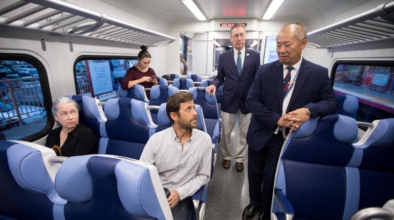 Eng, right, speaks with commuter Todd Orelli of Huntington on...