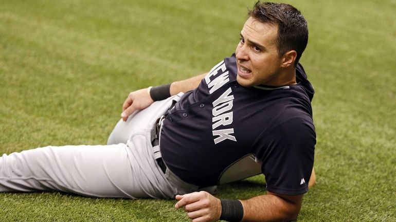 Yankees' Mark Teixeira stretches on the field for batting practice...