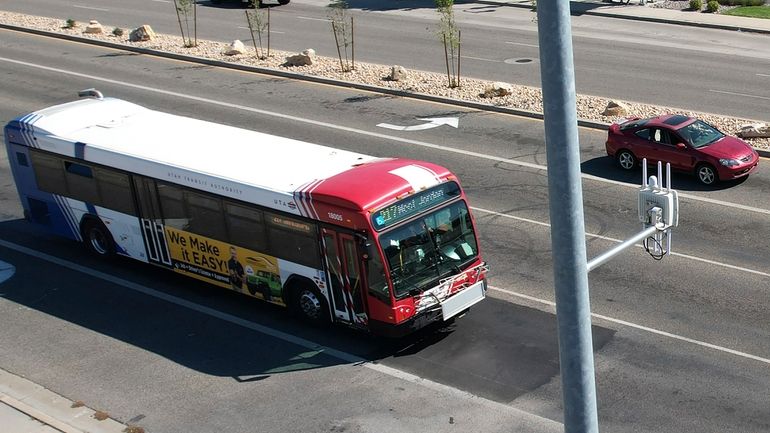 A commuter bus equipped with a radio transmitter approaches a...