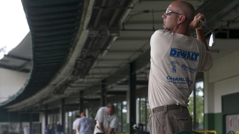 Joe Amdio of Massapequa practices his swing at SkyDrive Golf...