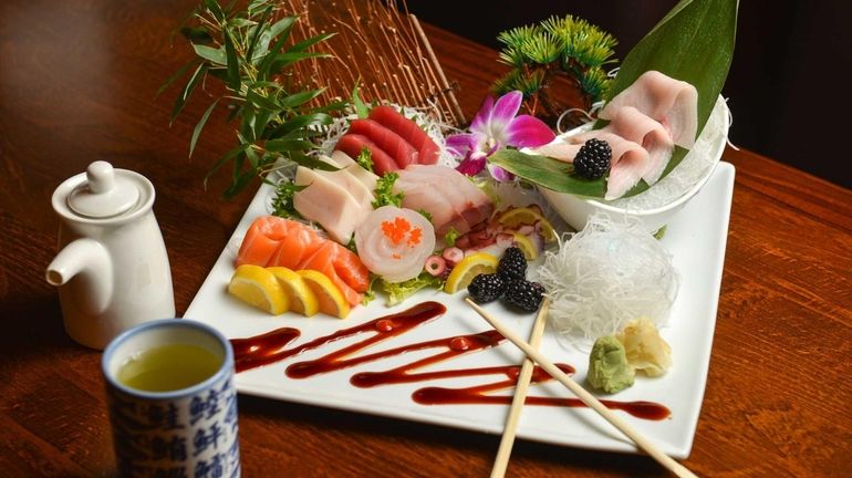 Sashimi deluxe, with 18 pieces of raw fish, is a...