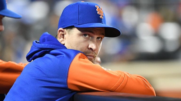 Mets pitcher Jacob deGrom looks on from the dugout during...