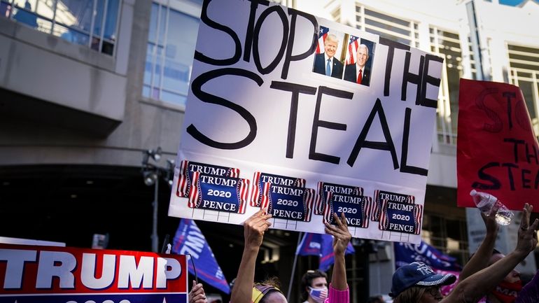 President Donald Trump supporters gather with some signs claiming a...