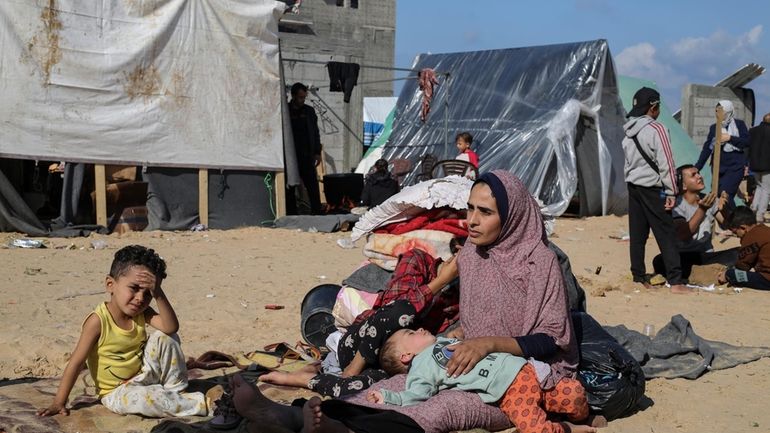 Palestinians displaced by the Israeli bombardment of the Gaza Strip...