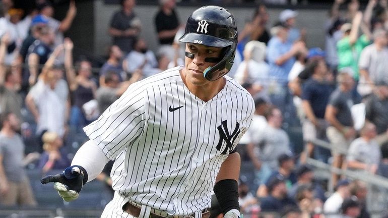 Yankees outfielder Aaron Judge points to the dugout after hitting...