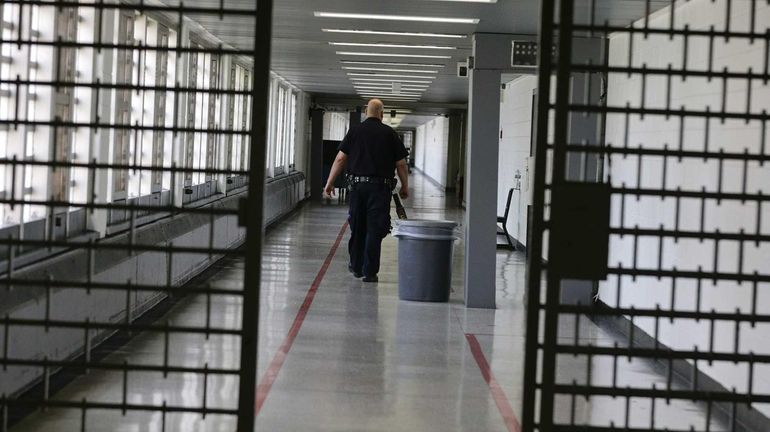 A Rikers Island juvenile detention facility officer walks down a...