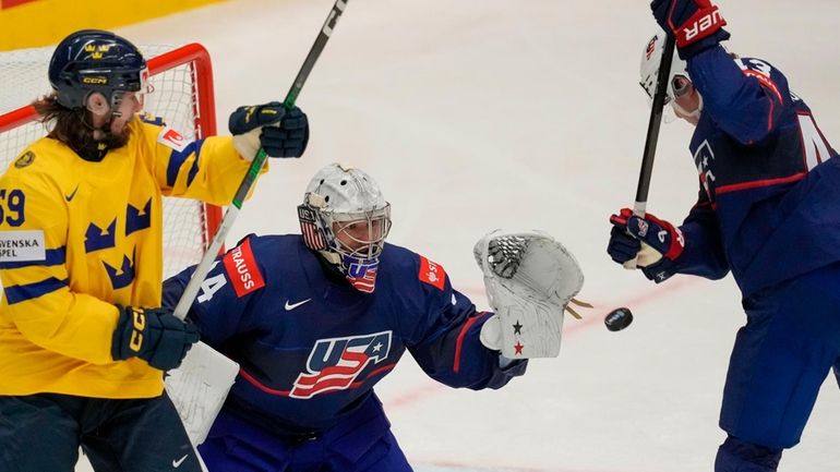 Unted States' goalkeeper Alex Lyon, center, makes a save in...