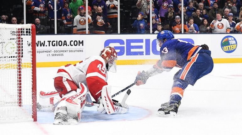 New York Islanders center Mathew Barzal shoots to score the...