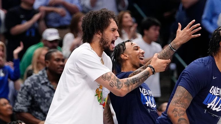 Injured Dallas Mavericks center Dereck Lively II, left, reacts to...