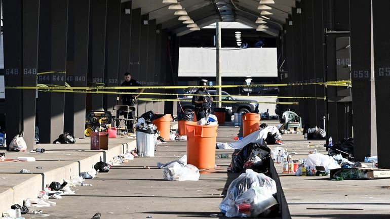 Officers stand behind police tape seen at the scene of...