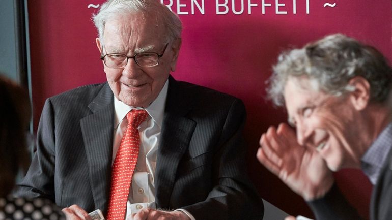 Warren Buffett, Chairman and CEO of Berkshire Hathaway, left, plays...