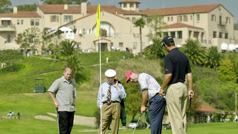 With the historic clubhouse in the background, Duffy Waldorf takes...