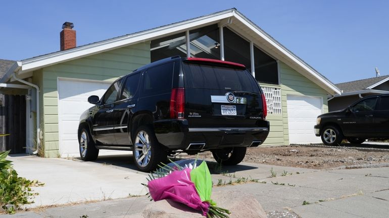 Flowers are seen in front of a home at a...