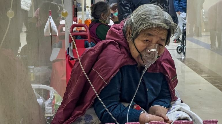 An elderly patient receives an intravenous drip while using a...