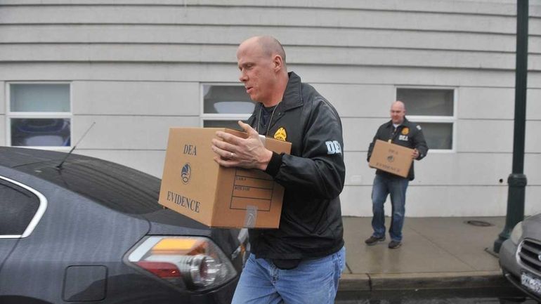 D.E.A. agents remove boxes of evidence from the medical offices...