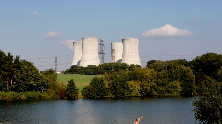 A man fishes with the towering Dukovany nuclear power plant...