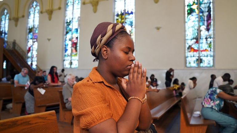 Marie Morette, a congregant of St Raphael Catholic church, prays...