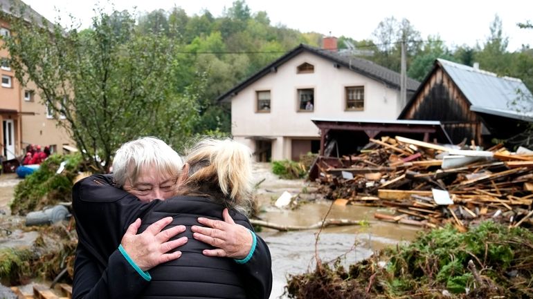 A resident hugs with her relative after being evacuated from...