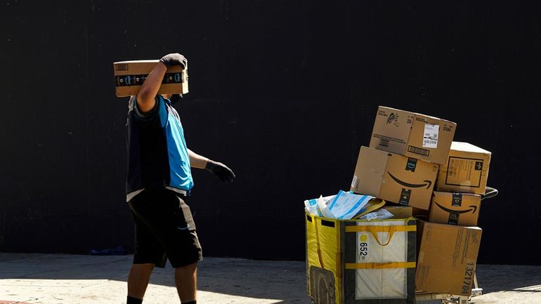 An Amazon worker delivers packages in Los Angeles on Oct....