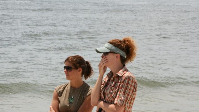 Unidentified people watch during the rescue effort at Long Beach...