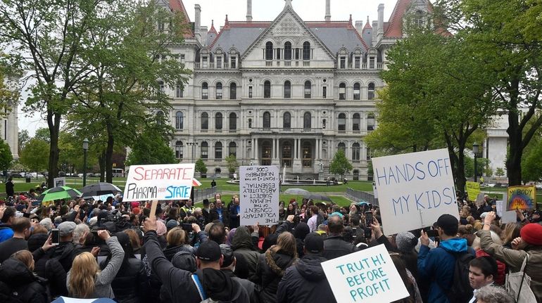 Protesters stand in the rain in May while rallying outside...