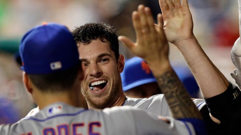 Mets pitcher Steven Matz celebrates with Wilmer Flores in the...