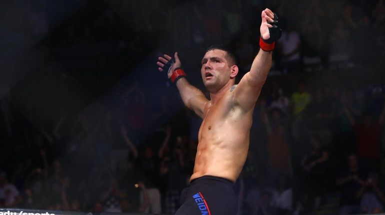 Middleweight Chris Weidman celebrates after defeating Kelvin Gastelum during the...