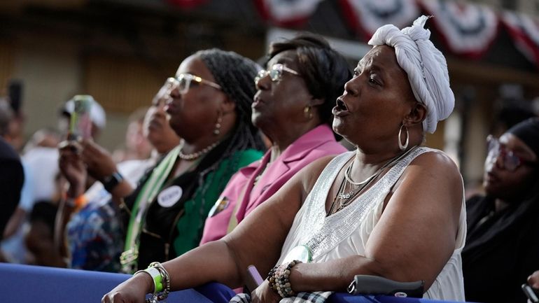 People listen as President Joe Biden speaks during a campaign...