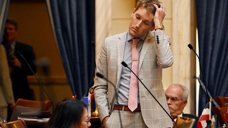 Sen. Nate Blouin, D-Salt Lake City, puts his hand through...