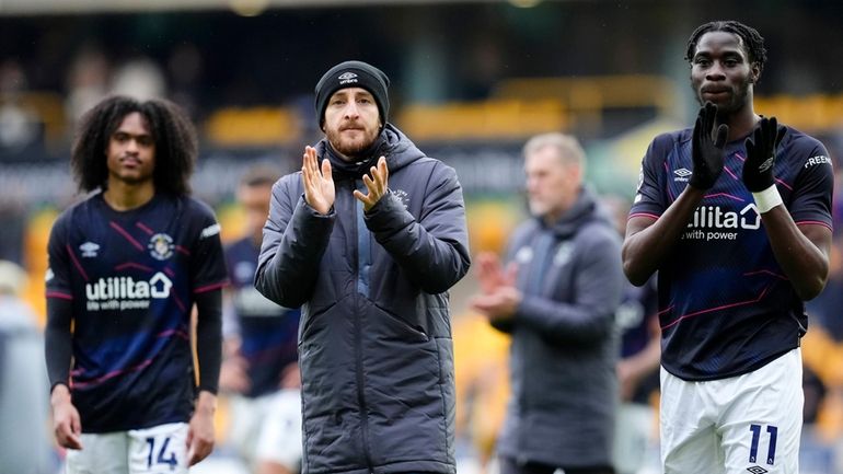 Luton Town's Tom Lockyer, centre, and team-mate Elijah Adebayo applaud...