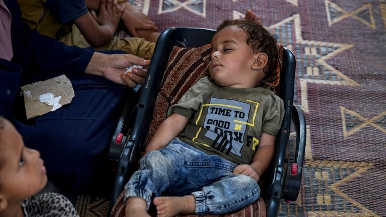 Displaced infant Abdel-Rahman Abuel-Jedian, who suffers from polio, sleeps at...