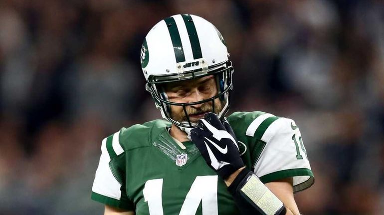 Ryan Fitzpatrick #14 of the New York Jets walks back...