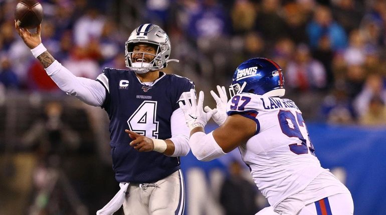 Dexter Lawrence of the New York Giants pursues Dak Prescott...