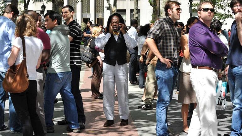 A man speaks on his cell phone as others wait...