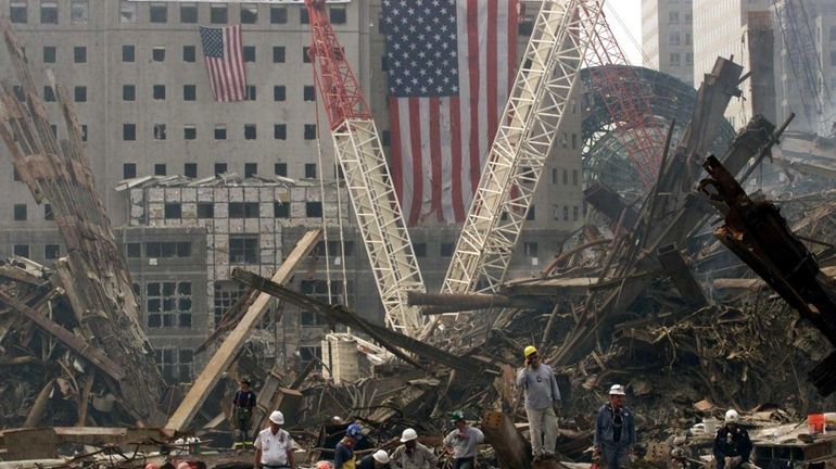 Rescue workers search through the wreckage of the World Trade...