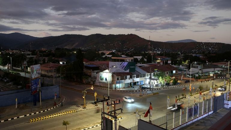 A street light is seen during a sunrise in Dili,...