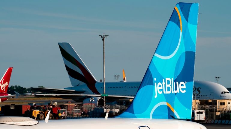 A JetBlue airplane is seen parked on the tarmac at...