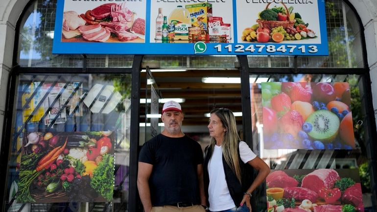 Sergio Gómez and Carla Cavallini pose for a picture outside...