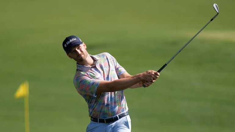 Wyndham Clark warms up on the driving range before a...