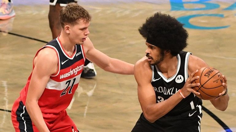 Nets center Jarrett Allen is defended by Wizards center Moritz...