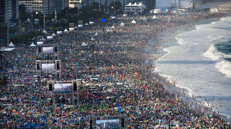 Pilgrims and residents gather on Copacabana beach before the arrival...