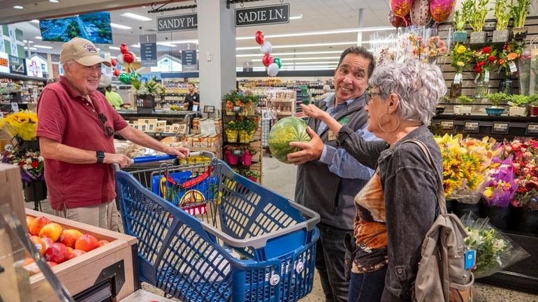 Fresh Grocer employee Greg Aureliano helps Carolyn and Aaron Lichter, of Bay...