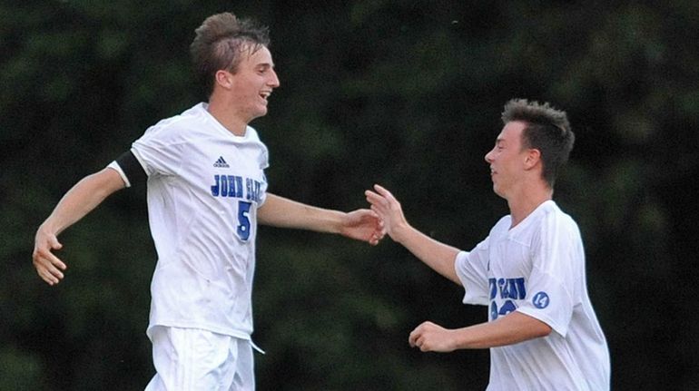 Andrew Lule #5 of Glenn, left, gets congratulated by teammate...